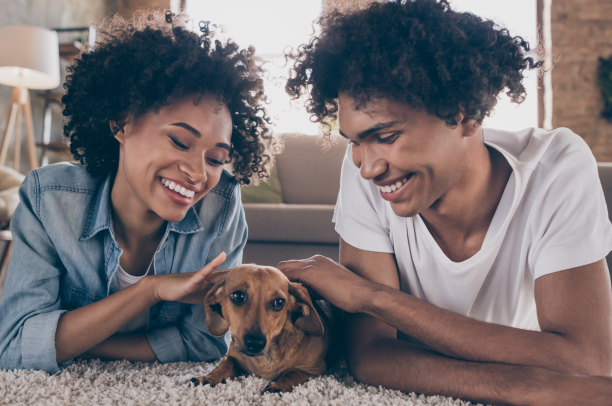 Homem e mulher com cachorrinho caramelo